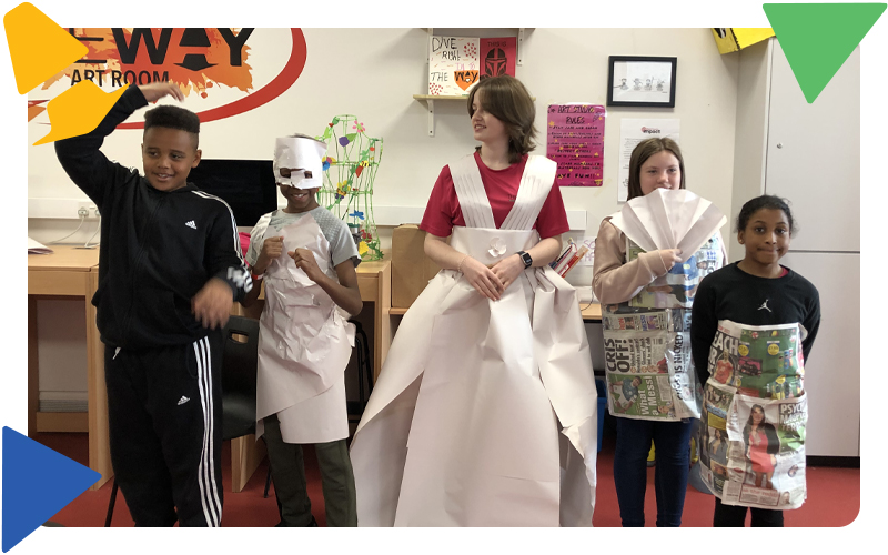 Four young children and a youth worker, dressed up in recycled paper fashion