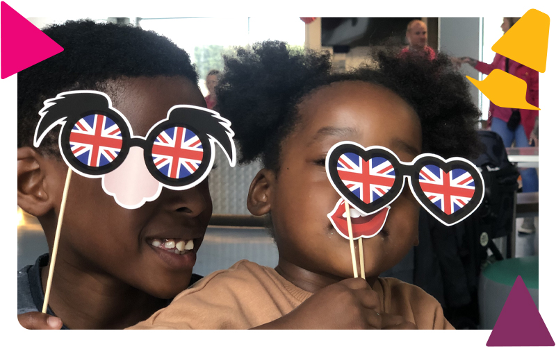 A boy and girl playing with photo booth props