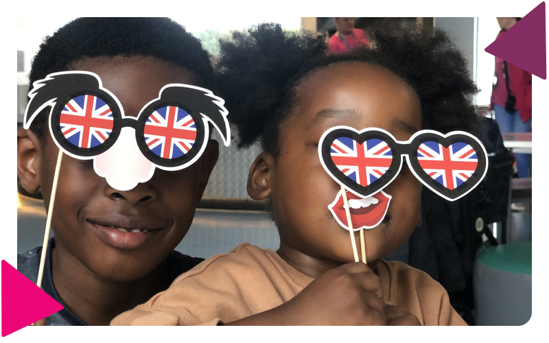 A boy and girl playing with photo booth props